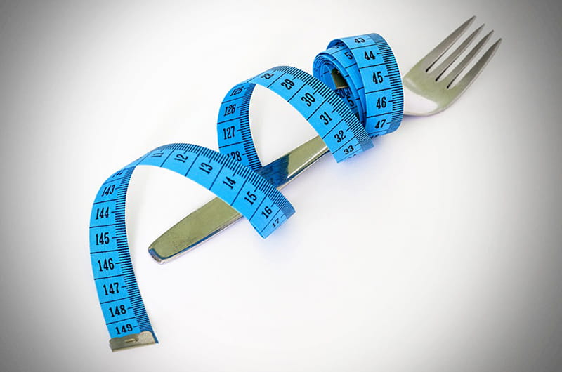 A measuring tape wrapped around a fork