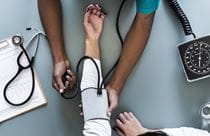 Doctor taking woman's blood pressure