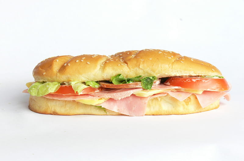 Hoagie with meat, cheese, lettuce and tomato.