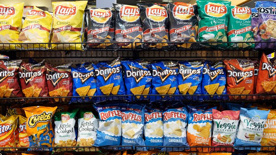 Facing a wall of chips and other ultra-processed snacks in a grocery store aisle