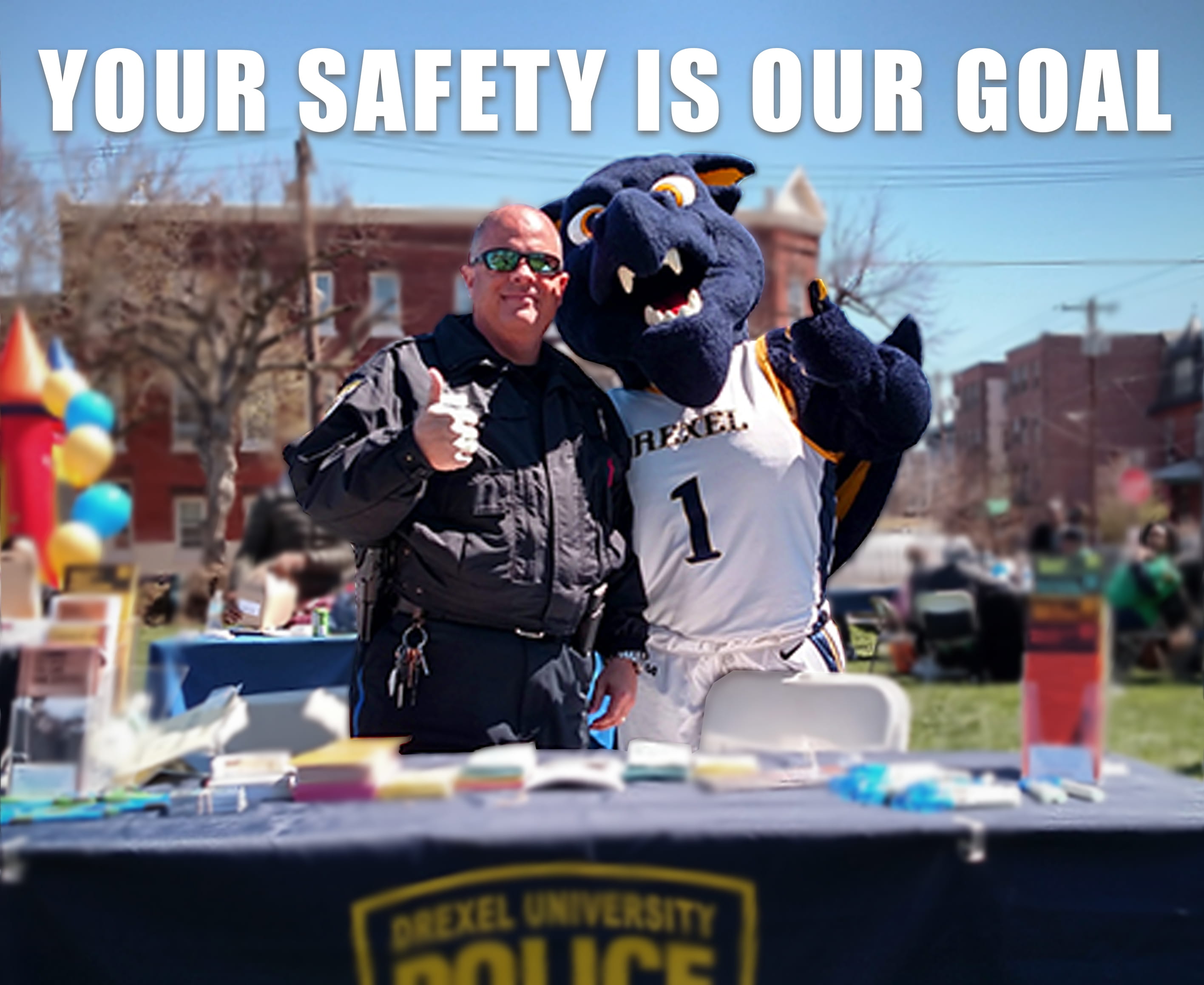 Drexel University police officer doing a thumbs-up gesture with Mario the Dragon Mascot.