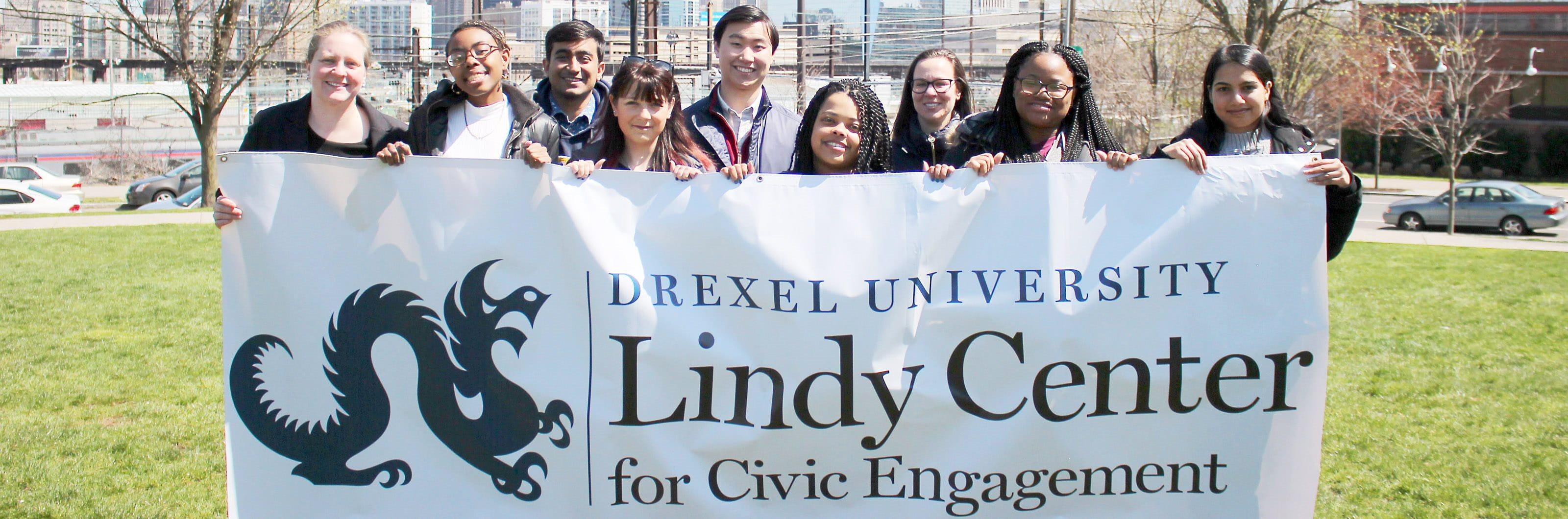 Students holding a sign that says Drexel University 林迪公民参与中心