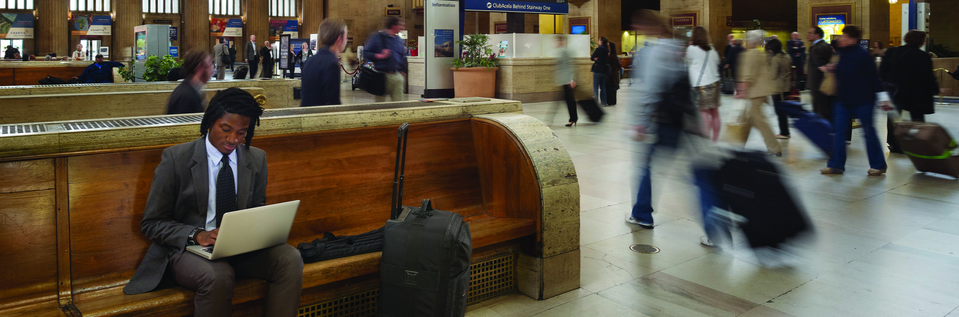 Interior shot of Philadelphia's 30th Street Station featuring commuter working on a laptop