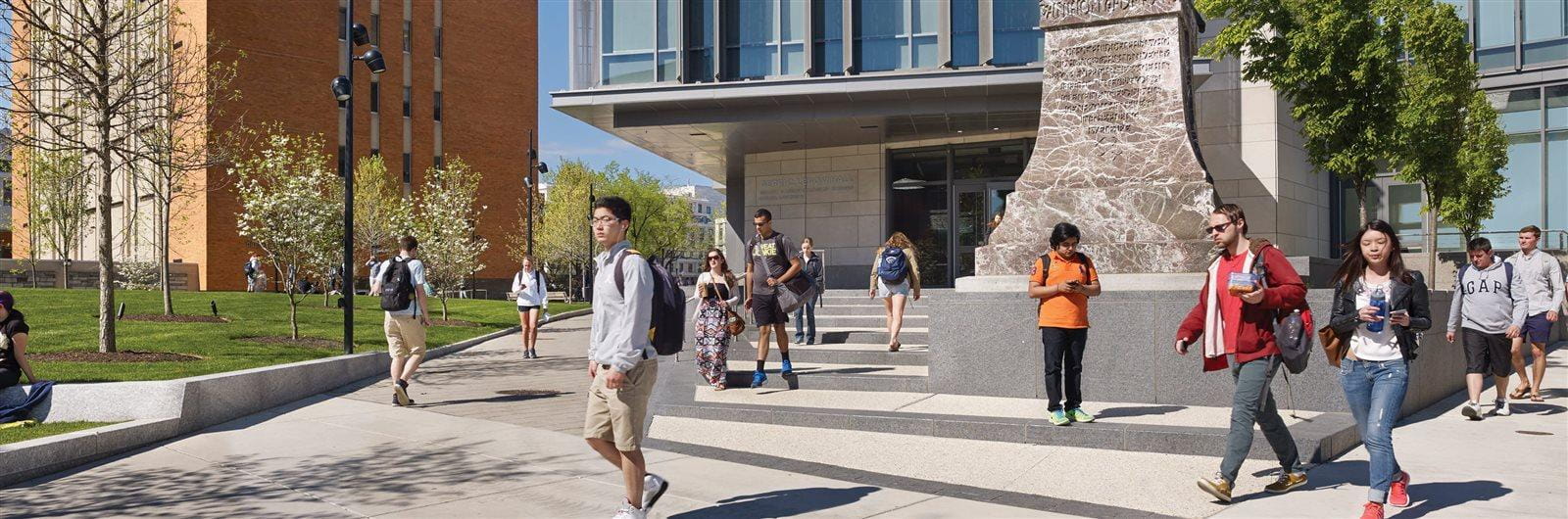 Students walking on campus in front of the statue of founder AJ Drexel.