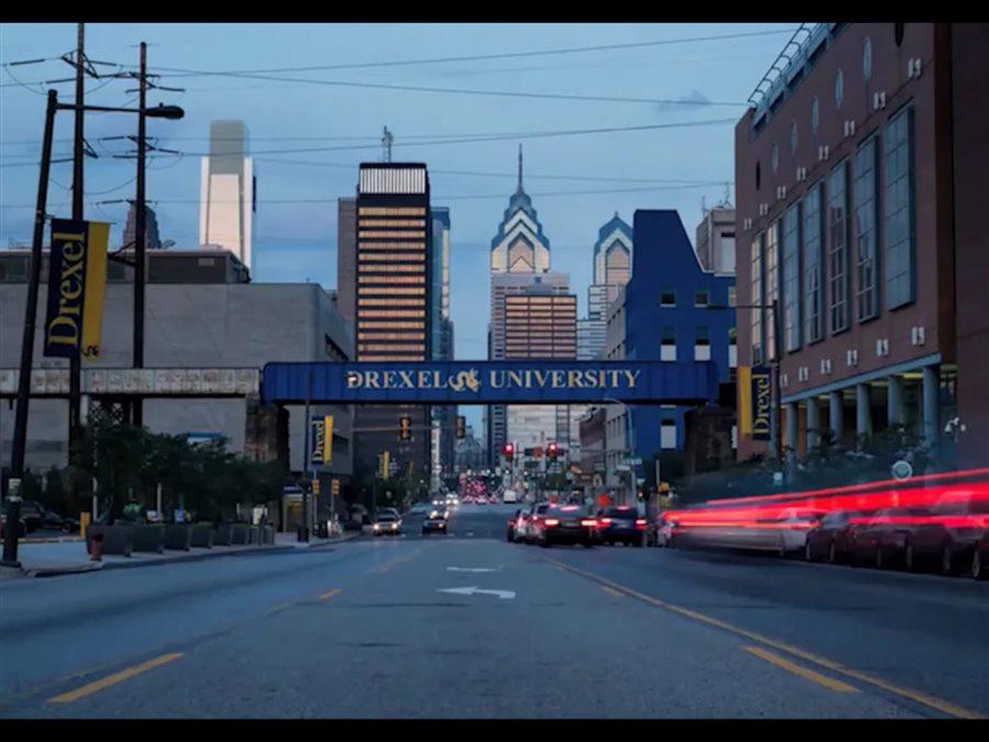 Philadelphia skyline with 'Drexel University' painted on a rail bridge in the foreground.