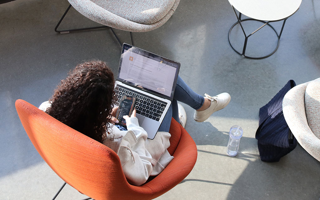 Student sitting with laptop and smart phone