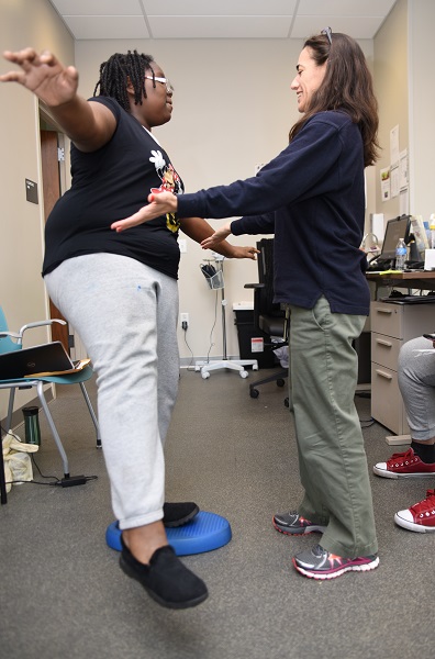 Sarah Wenger, PT, DPT works with a patient in the gym