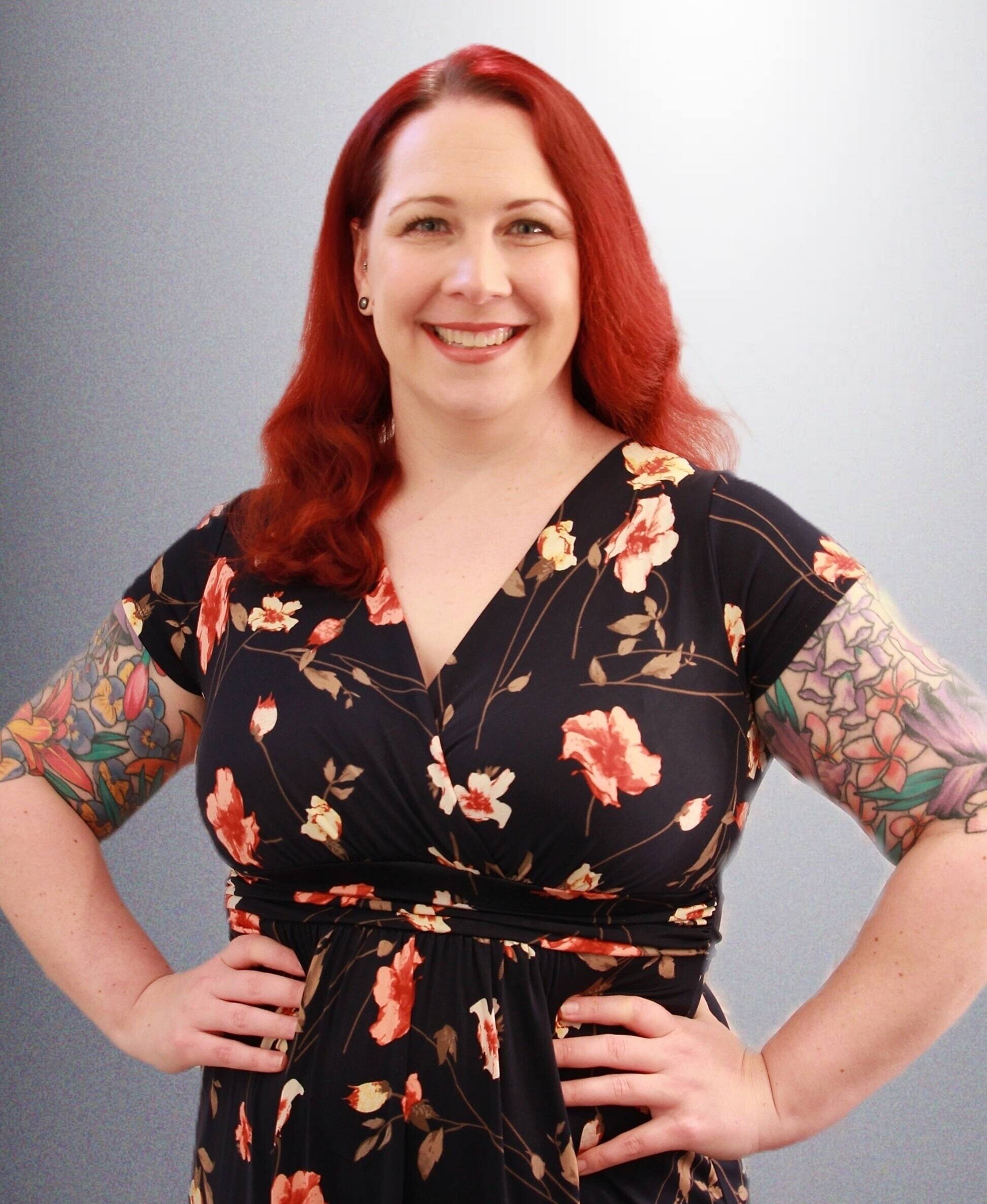 Angela Kapalko wearing floral dress standing with hands on hips