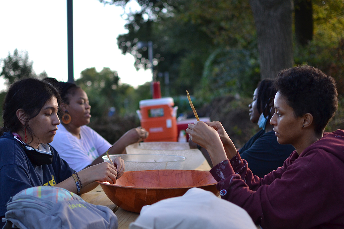 Participants shell crowder peas at a picnic table 