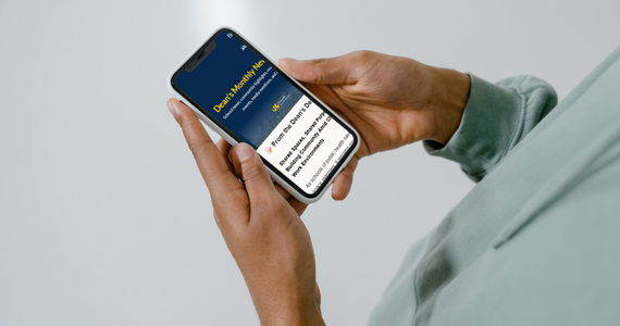 Person holding a smart phone device and viewing Dornsife's newsletter
