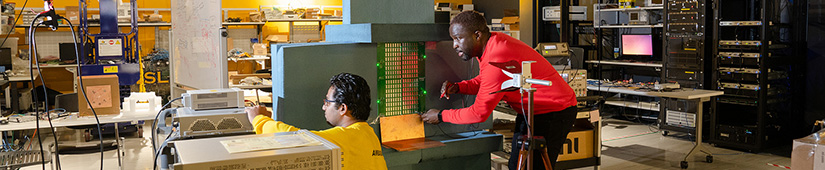 Two students working on computer equipment