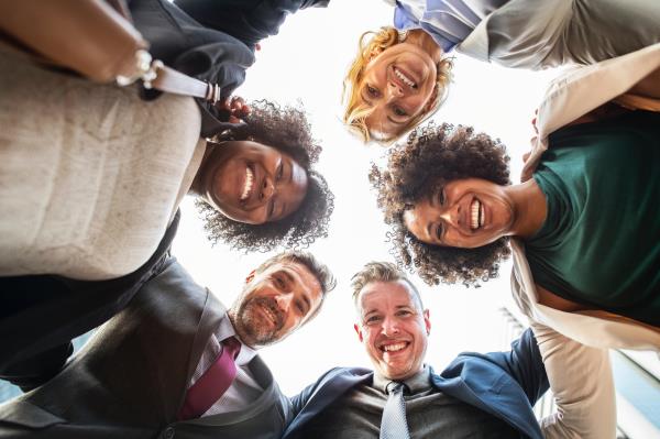 group of adults standing in circle, smiling