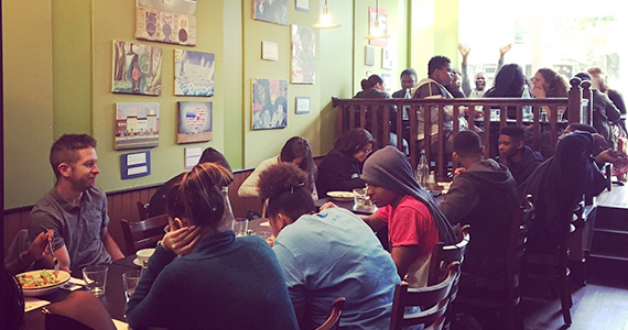 Large group of people sitting at tables at EAT Cafe