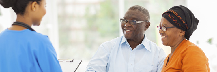 Nurse greeting senior couple at family medicine practice.