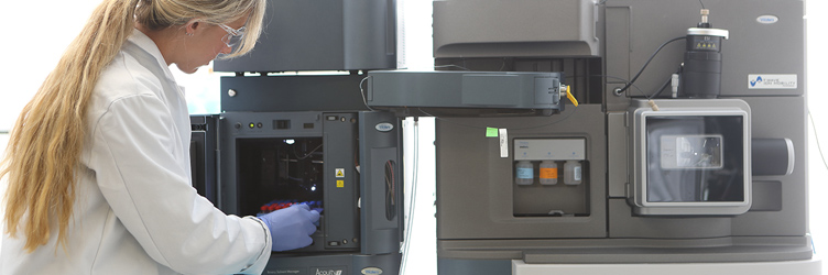 Female graduate student demonstrating lab equipment at Drexel University College of Medicine.