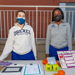 Drexel Medicine students at a community health event info table.