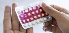 Woman holding birth control pills.