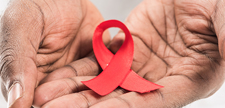 Hands holding red ribbon.