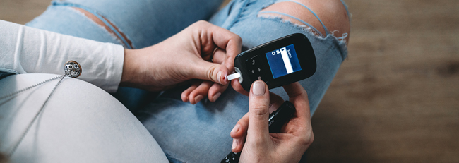 Pregnant woman testing blood sugar.