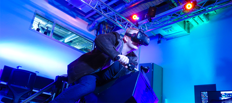 Student on a ridable VR motorcycle ride system.